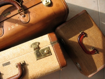 Three vintage leather suitcases representing the luggage repair services of Klumpps Leather & Luggage in Grand Rapids, MI